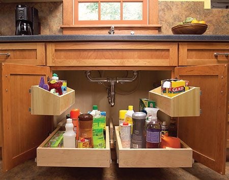 trays filled with items stored under the sink